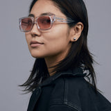 Brutal 3.0  Sunglasses by Tribu Eyewear — Crystal square acetate frame, sunset lens, female model light grey background.