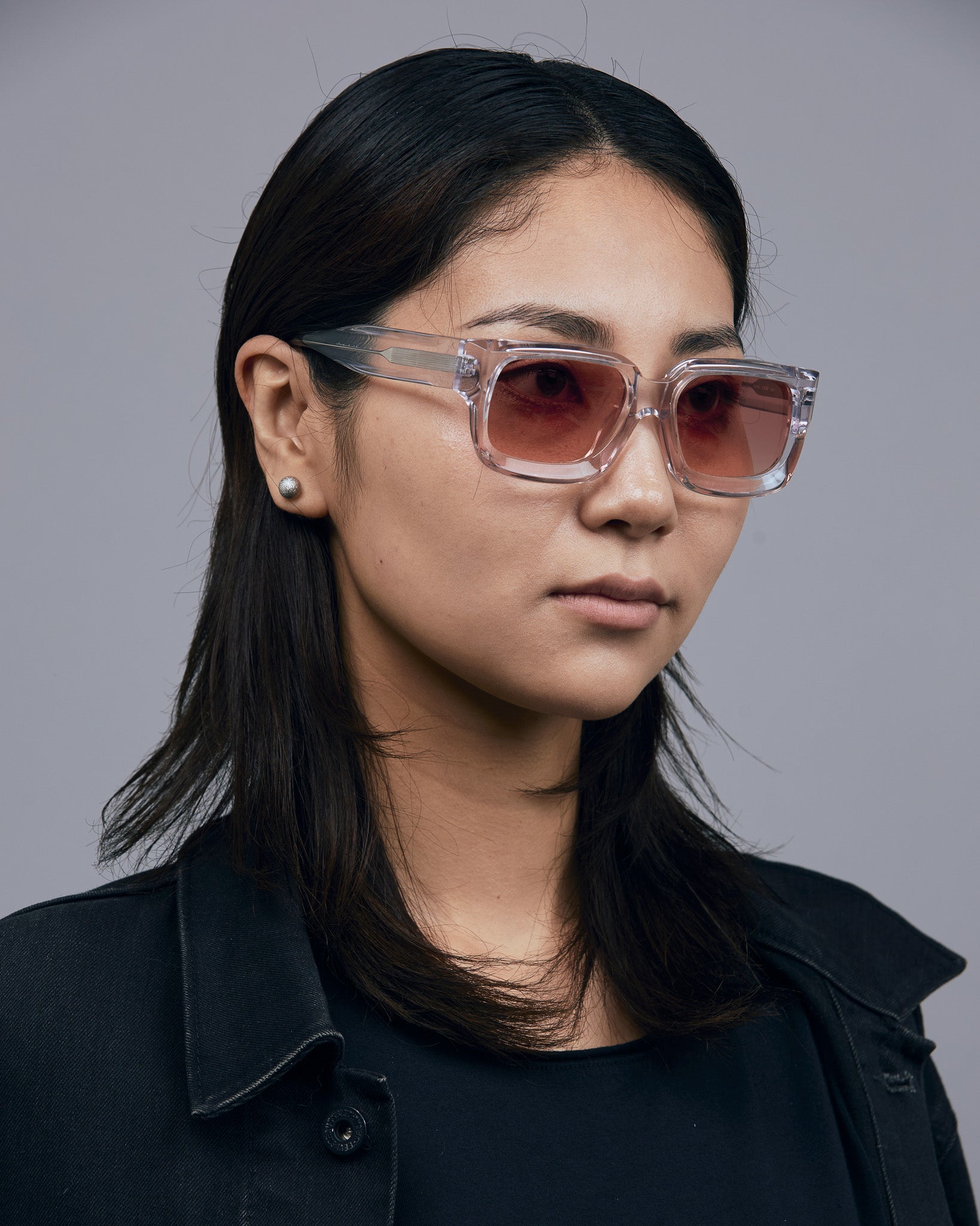 Brutal 3.0  Sunglasses by Tribu Eyewear — Crystal square acetate frame, sunset lens, on female model light grey background.