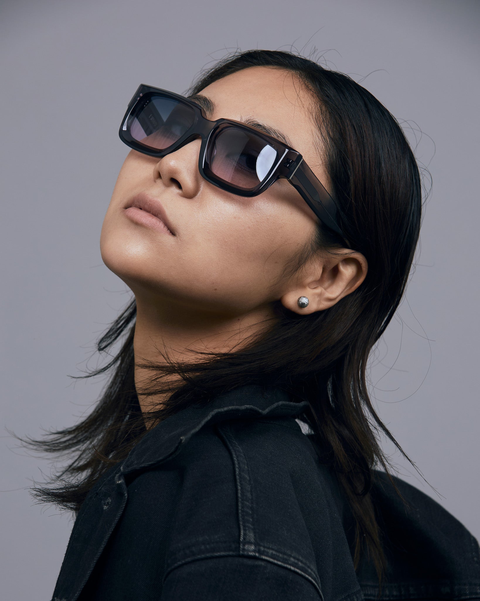 Brutal 3.0 Crystal Sunglasses by Tribu Eyewear — Smoke Crystal square acetate frame, Deep Ocean lens, female model light grey background.