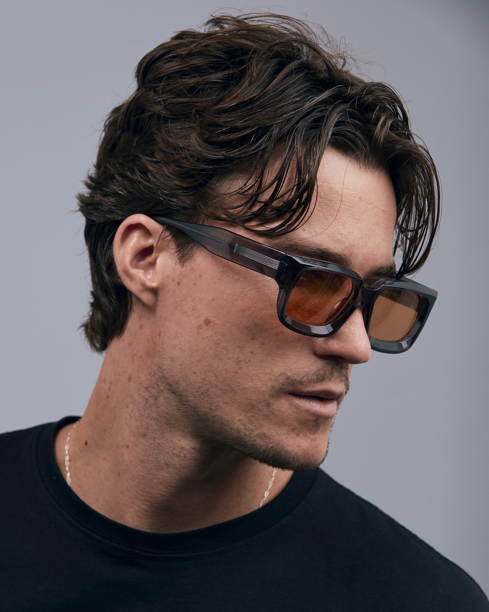 Brutal 3.0  Sunglasses by Tribu Eyewear — Smoke Crystal square acetate frame, desert orange lens, male model light grey background.
