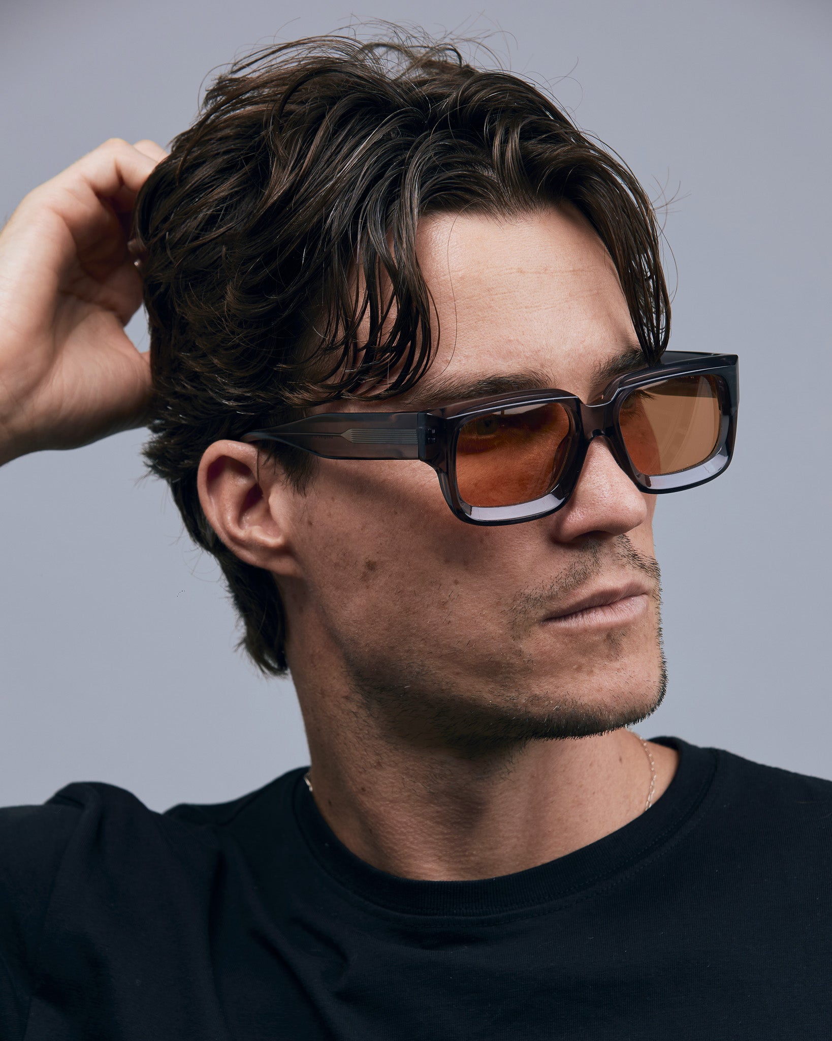 Brutal 3.0  Sunglasses by Tribu Eyewear — Smoke Crystal square acetate frame, desert orange lens, male model light grey background.