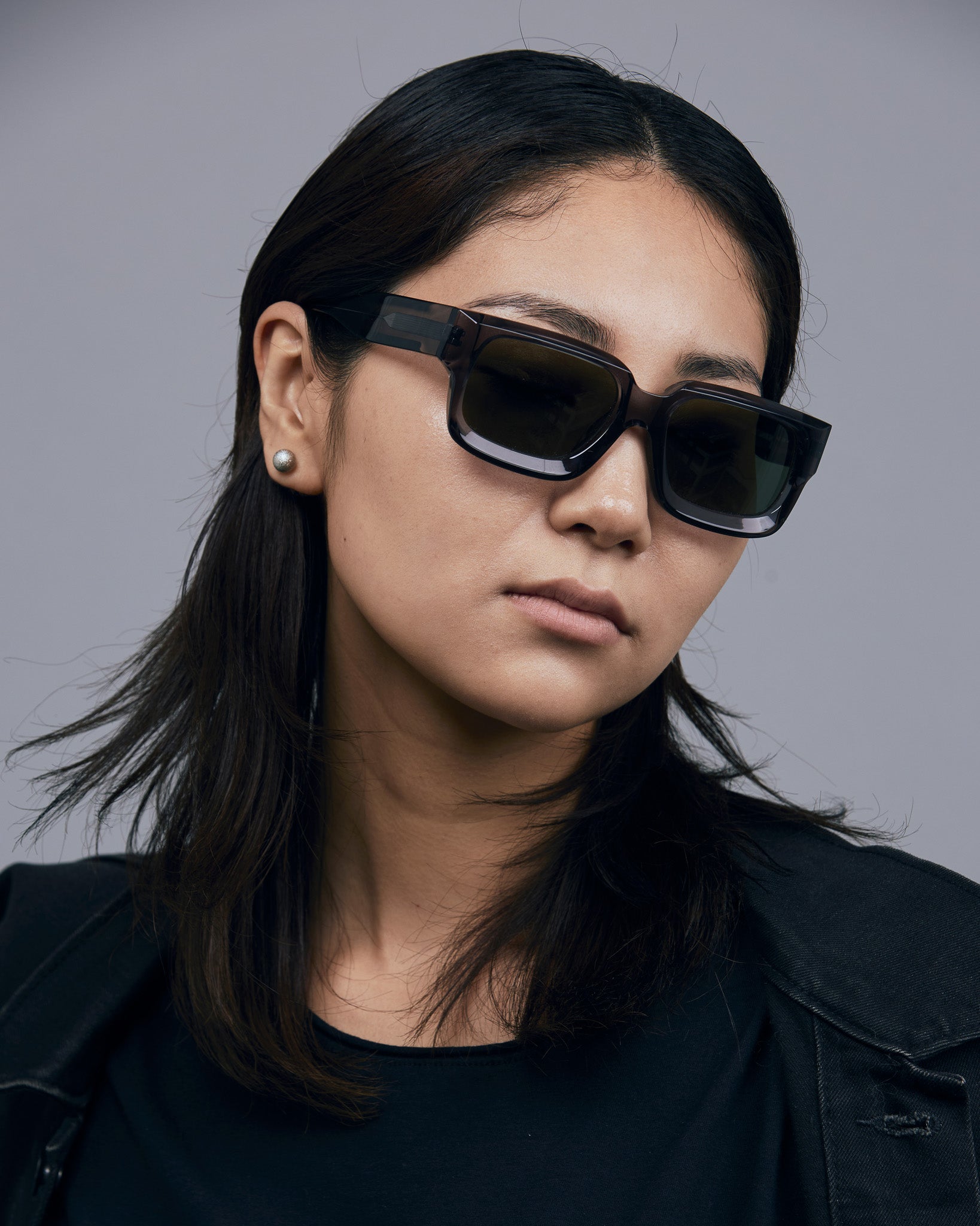 Brutal 3.0 Green Polarised Sunglasses by Tribu Eyewear — Smoke Crystal square acetate frame, female model light grey background.