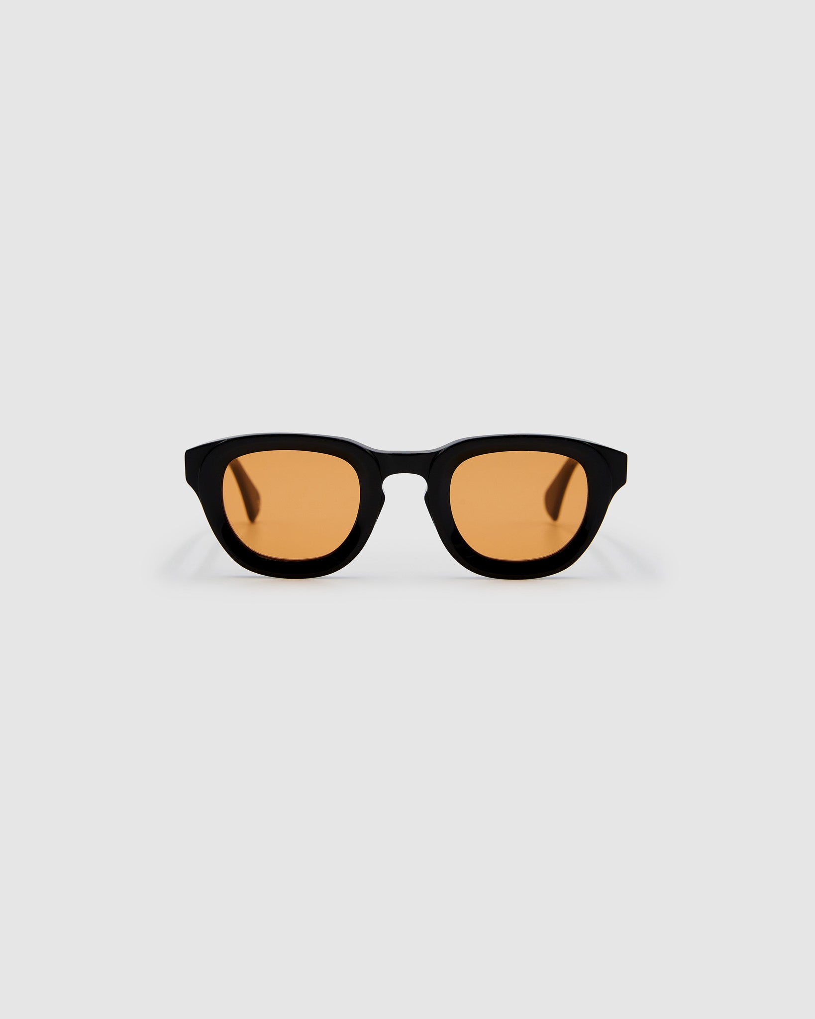 Brutal 4.0 Sunglasses by Tribu Eyewear — Black round acetate frame, desert orange lens, front view light grey background.