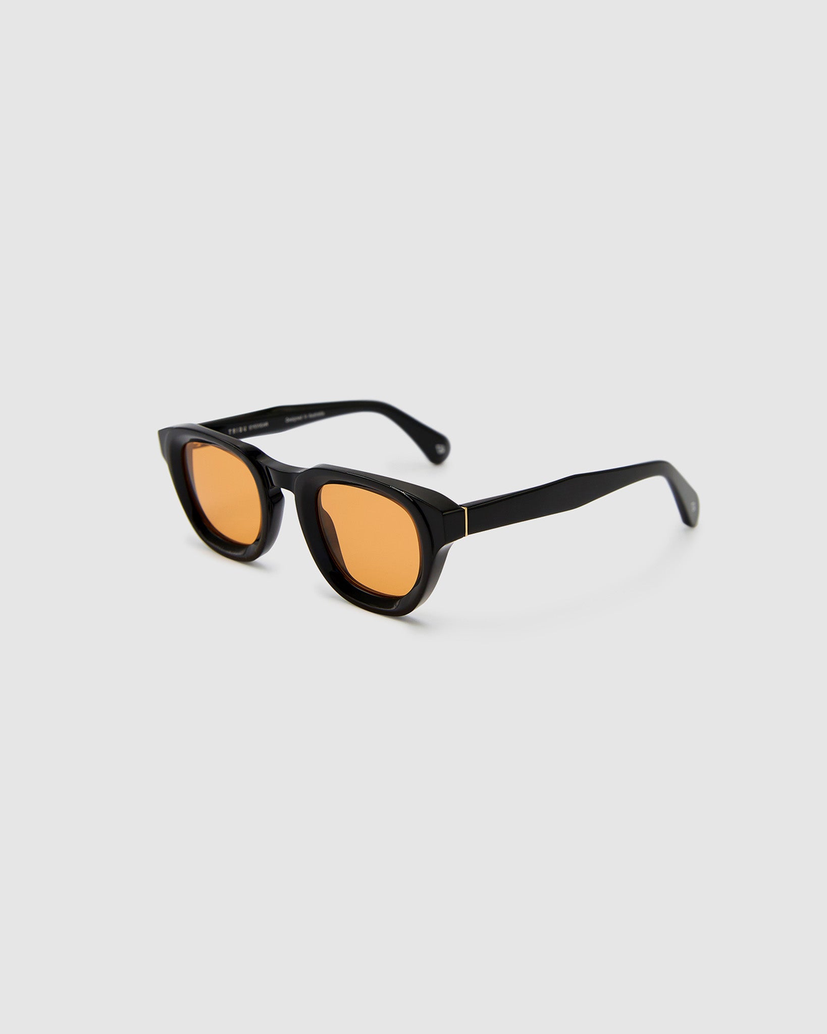 Brutal 4.0 Sunglasses by Tribu Eyewear — Black round acetate frame, desert orange lens, side view light grey background.