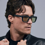 Brutal 5.0 Sunglasses by Tribu Eyewear — Matte black rectangular acetate frame, sage lens, on male light grey background.