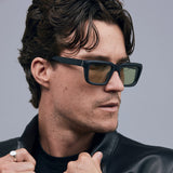 Brutal 5.0 Sunglasses by Tribu Eyewear — Matte black rectangular acetate frame, sage lens, on male light grey background.