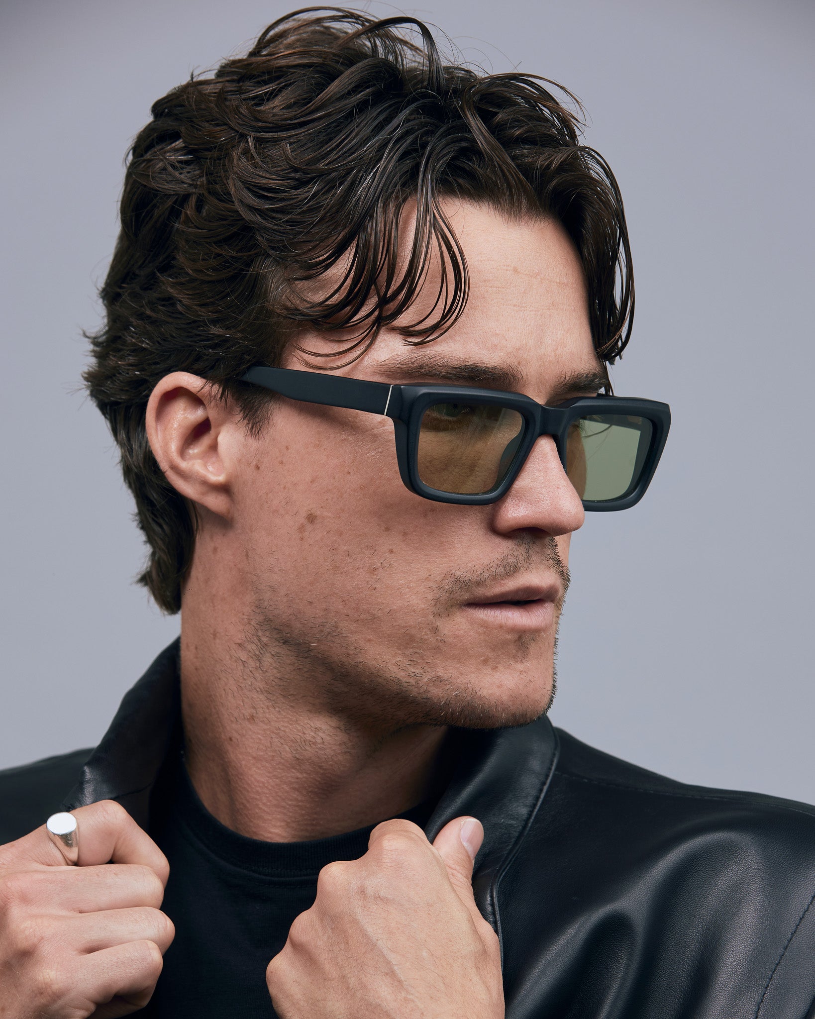 Brutal 5.0 Sunglasses by Tribu Eyewear — Matte black rectangular acetate frame, sage lens, on male light grey background.