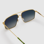 Fonda Sunglasses by Tribu Eyewear — Grey grad polarised lens in a brushed gold metal aviator frame, detailed view on a grey background.