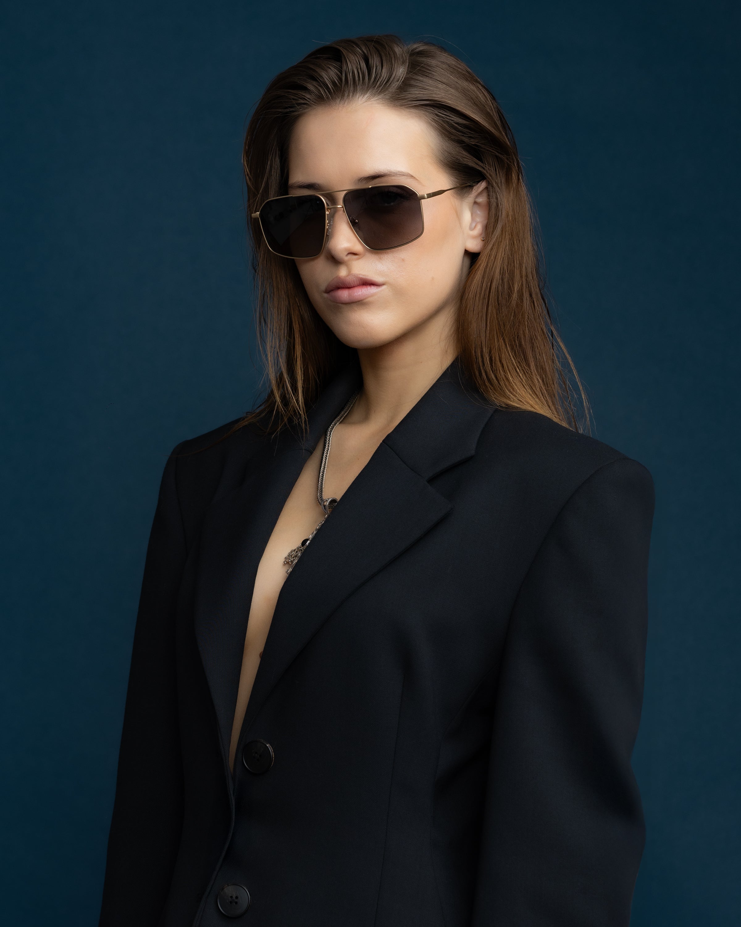 Fonda Sunglasses by Tribu Eyewear — Grey grad polarised lens in a brushed gold metal aviator frame on a female model. 
