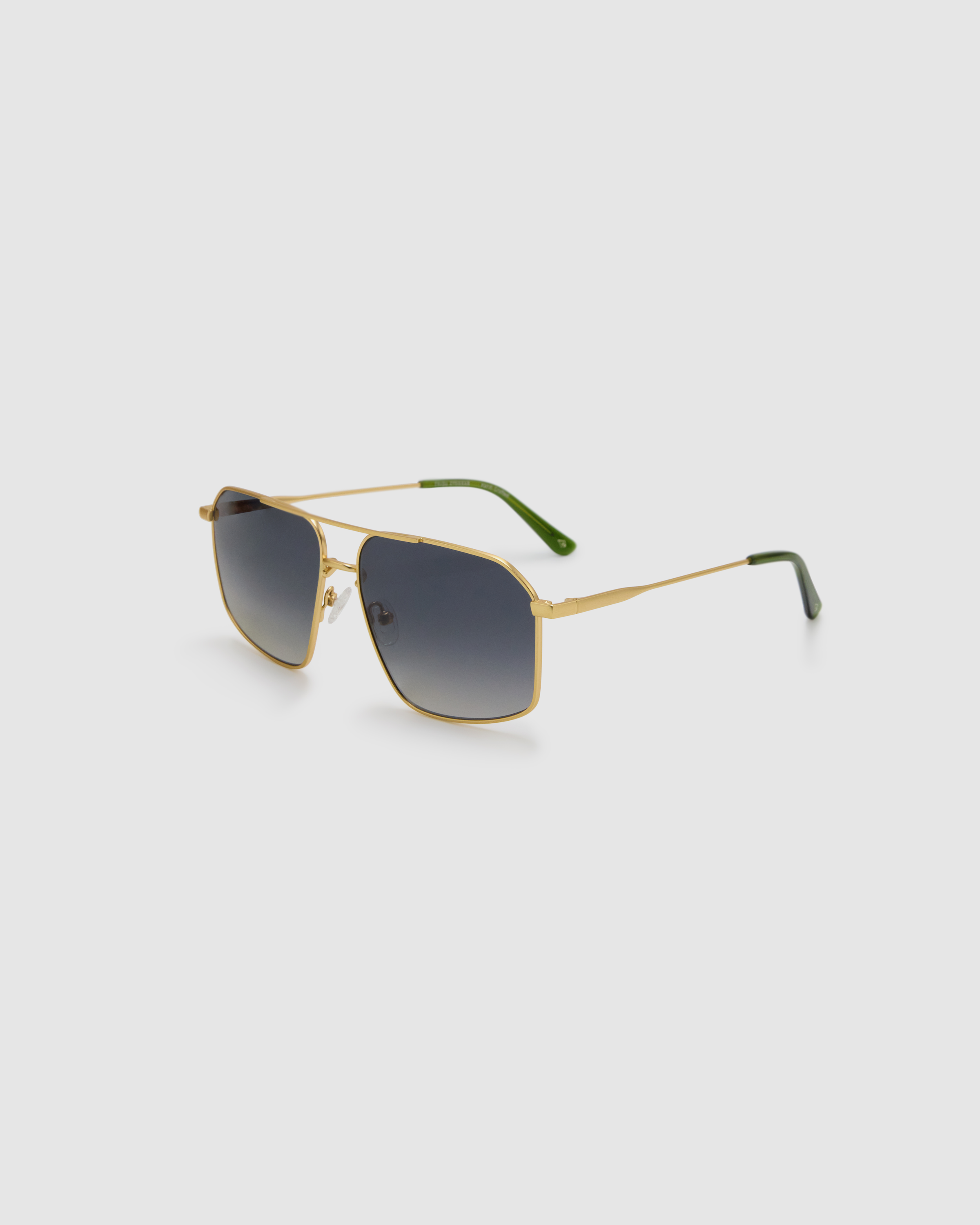 Fonda Sunglasses by Tribu Eyewear — Grey grad polarised lens in a brushed gold metal aviator frame, side view on a grey background.
