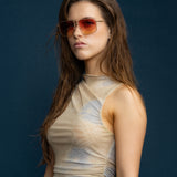 Fonda Gold Sunglasses by Tribu Eyewear  — Fine wire metal aviator frame, sunset tint lens on female model. 