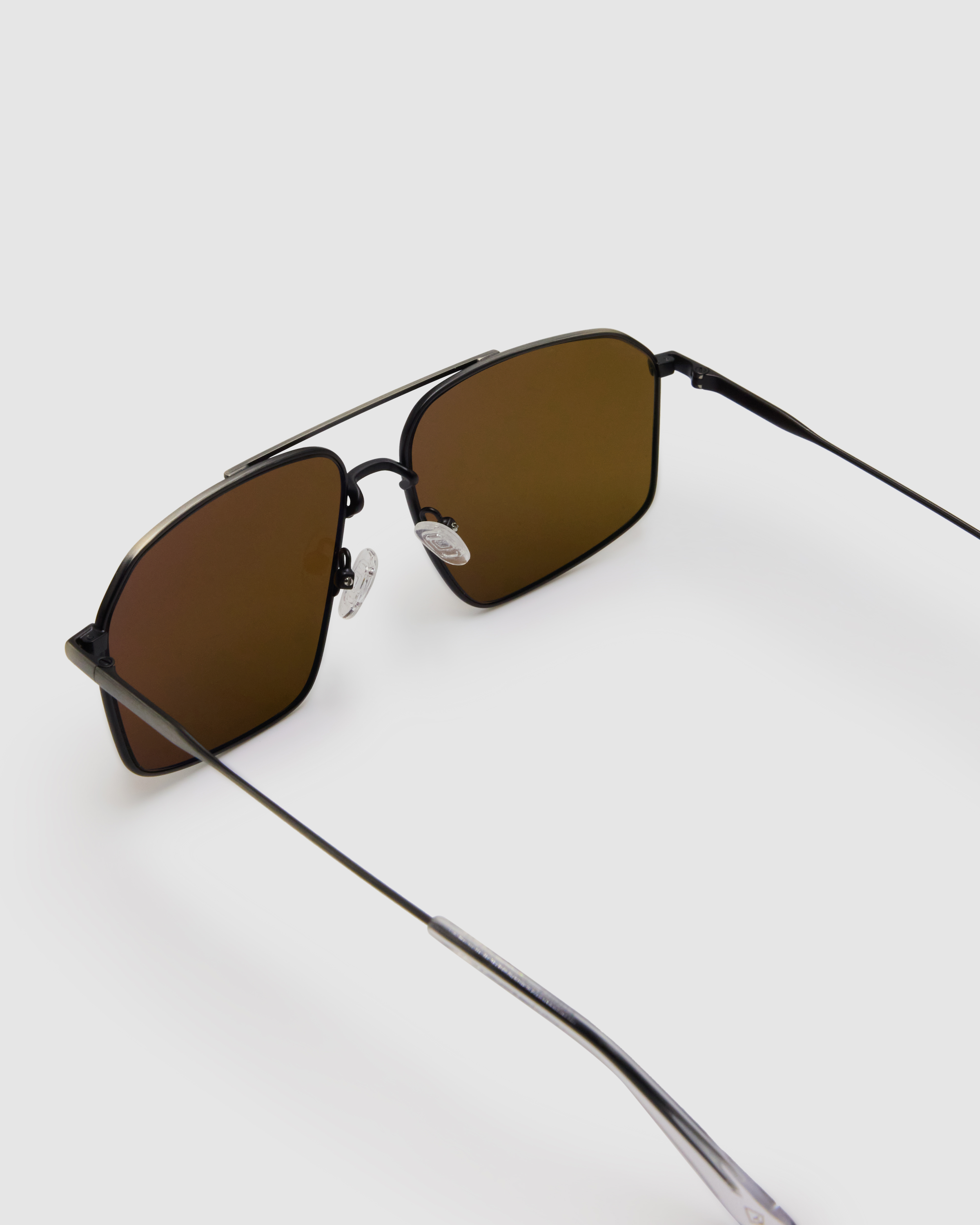 Fonda Sunglasses by Tribu Eyewear — Brown polarised lens in a gun metal aviator frame, detailed view on a grey background.