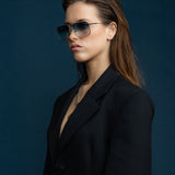 Fonda Silver Sunglasses by Tribu Eyewear  — Fine wire metal aviator frame, blue sky lens on female model.
