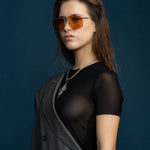 Fonda Silver Sunglasses by Tribu Eyewear  — Fine wire metal aviator frame, desert orange lens on female model.