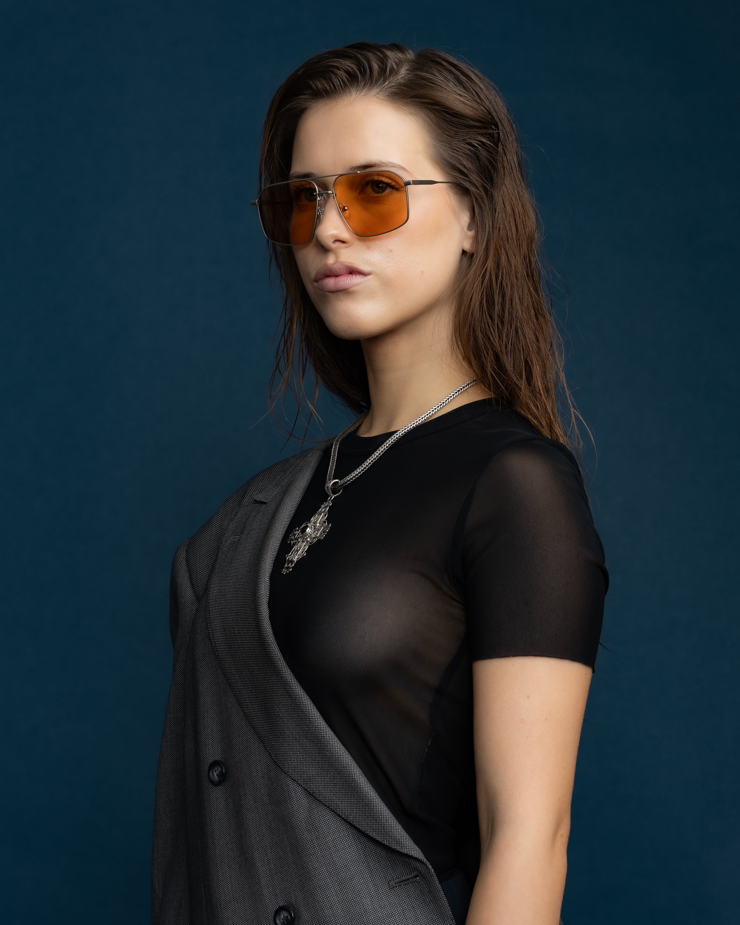 Fonda Silver Sunglasses by Tribu Eyewear  — Fine wire metal aviator frame, desert orange lens on female model.