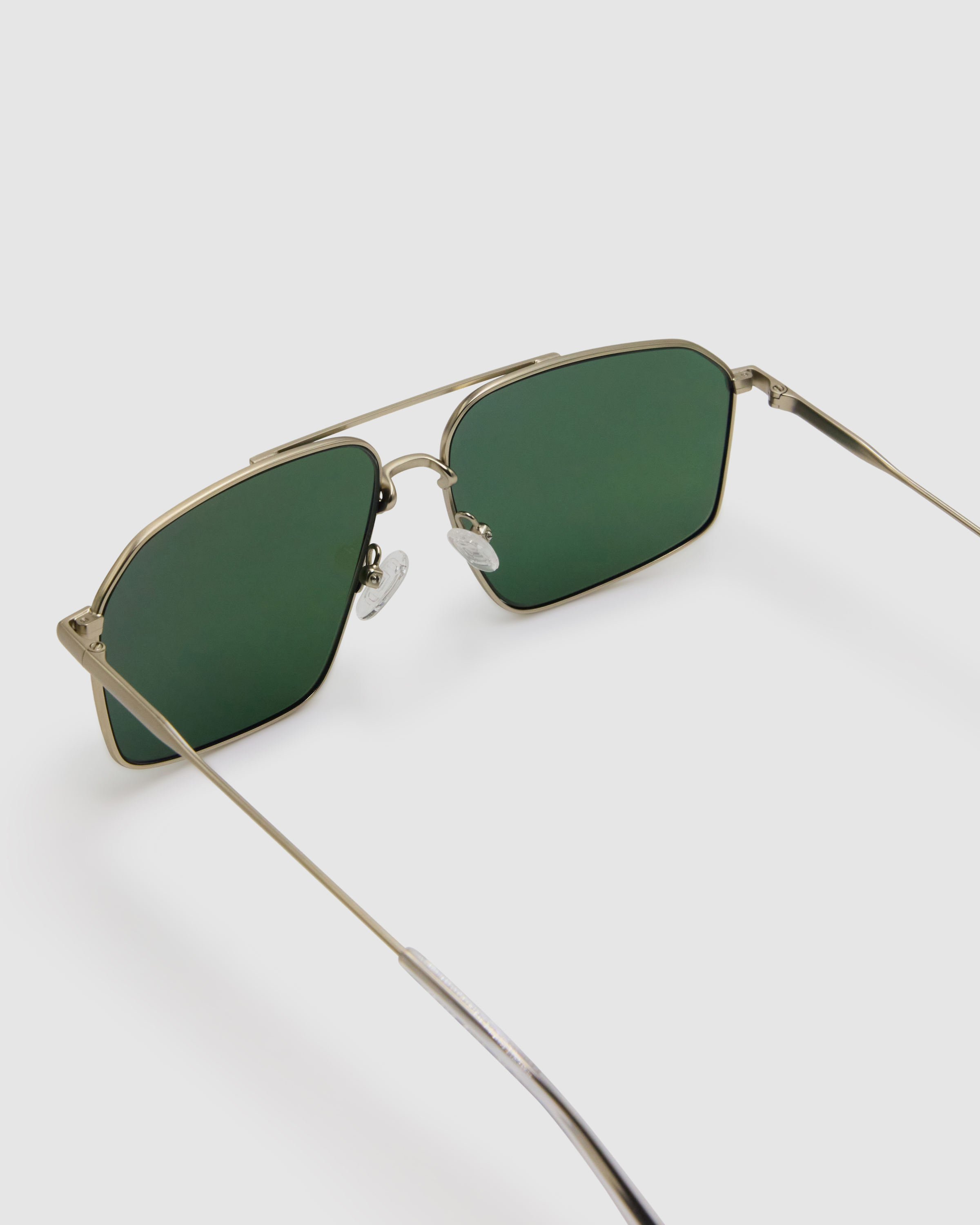 Fonda Sunglasses by Tribu Eyewear — Green polarised lens in a Silver metal aviator frame, detailed view on a grey background.