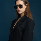 Fonda Sunglasses by Tribu Eyewear — Green polarised lens in a Silver metal aviator frame on a female model.