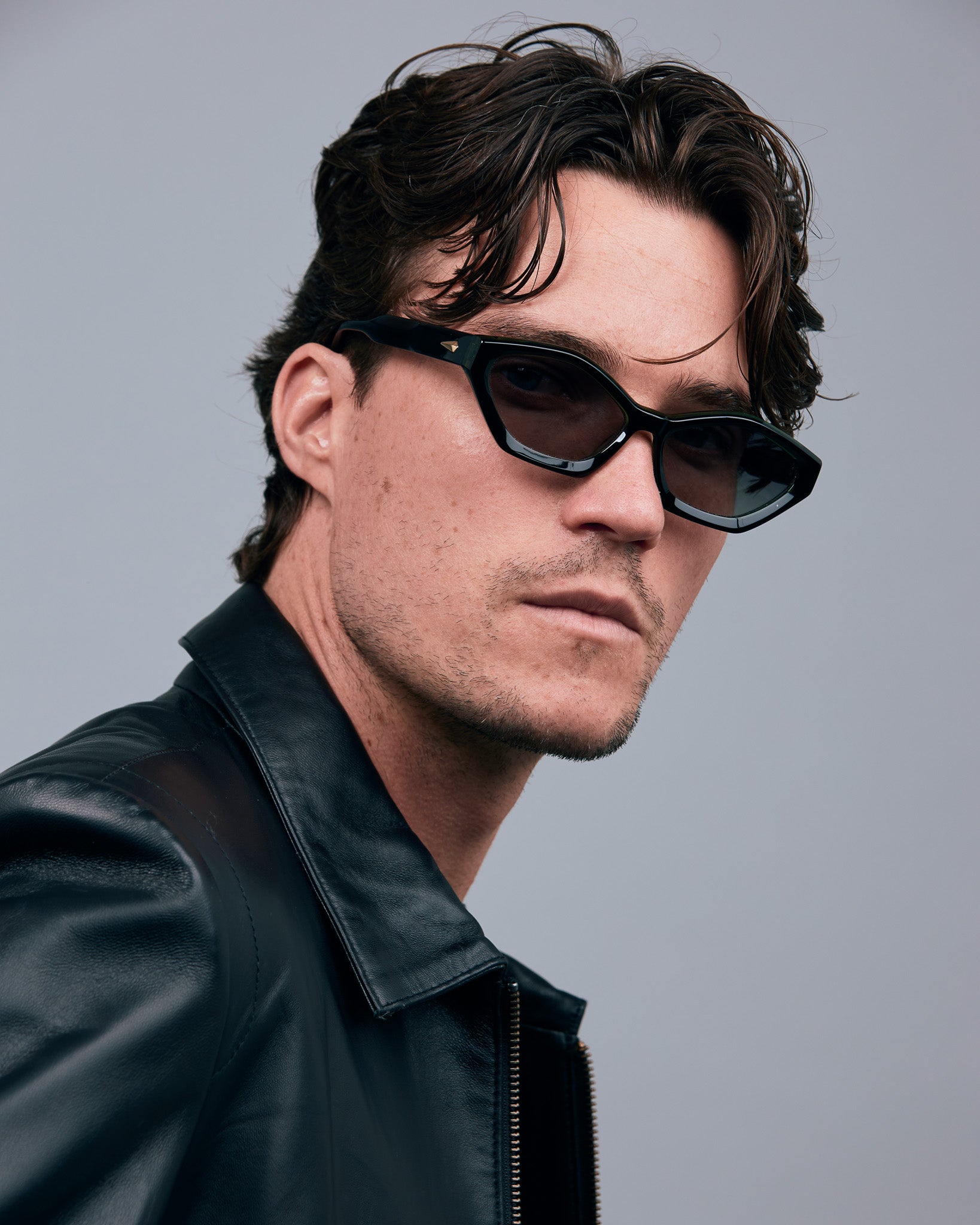 Franky Polarised Sunglasses by Tribu Eyewear — Black on Green Acetate Cat-eye frame with grey lens, front male model grey background.