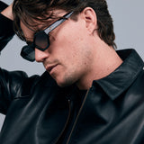 Franky Polarised Sunglasses by Tribu Eyewear — Black on Green Acetate Cat-eye frame with grey lens, side male model grey background.