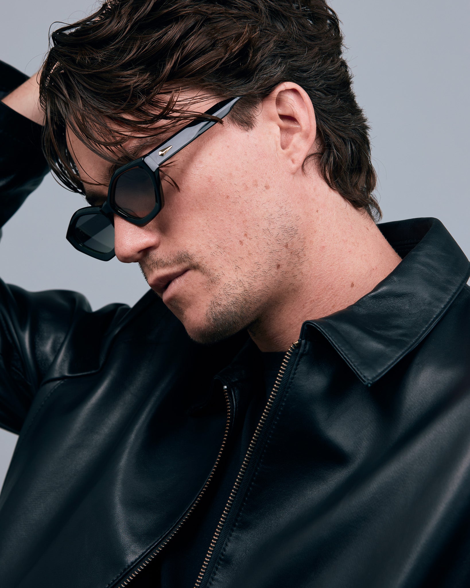 Franky Polarised Sunglasses by Tribu Eyewear — Black on Green Acetate Cat-eye frame with grey lens, side male model grey background.