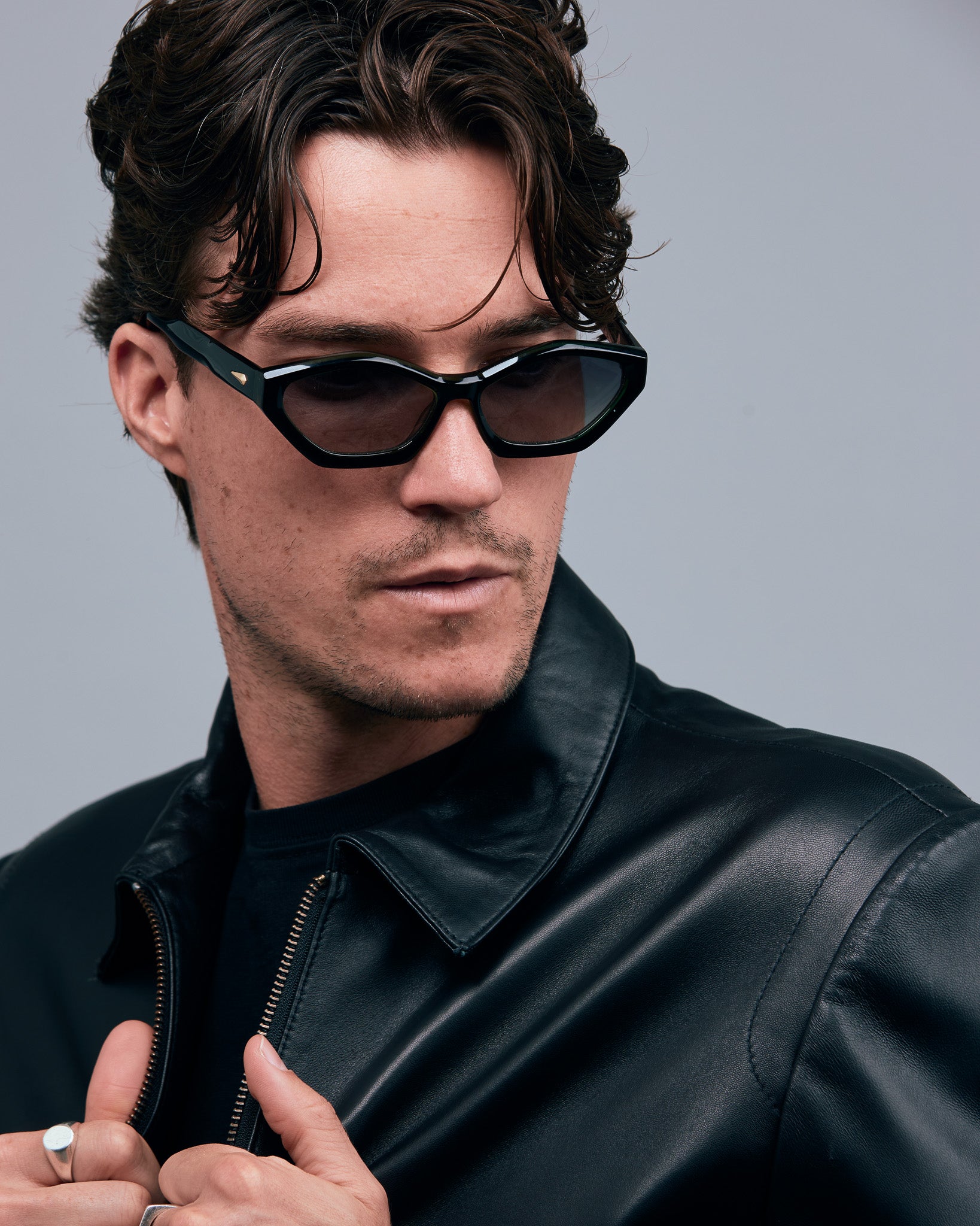 Franky Polarised Sunglasses by Tribu Eyewear — Black on Green Acetate Cat-eye frame with grey lens, male model grey background.