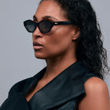 Franky Polarised Sunglasses by Tribu Eyewear — Black on Red Acetate Cat-eye frame with grey lens, side female model grey background.