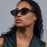 Franky Polarised Sunglasses by Tribu Eyewear — Black on Red Acetate Cat-eye frame with grey lens, female model.