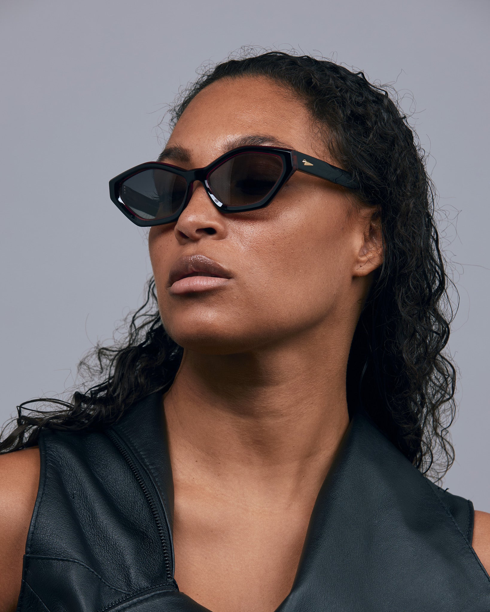 Franky Polarised Sunglasses by Tribu Eyewear — Black on Red Acetate Cat-eye frame with grey lens, female model.