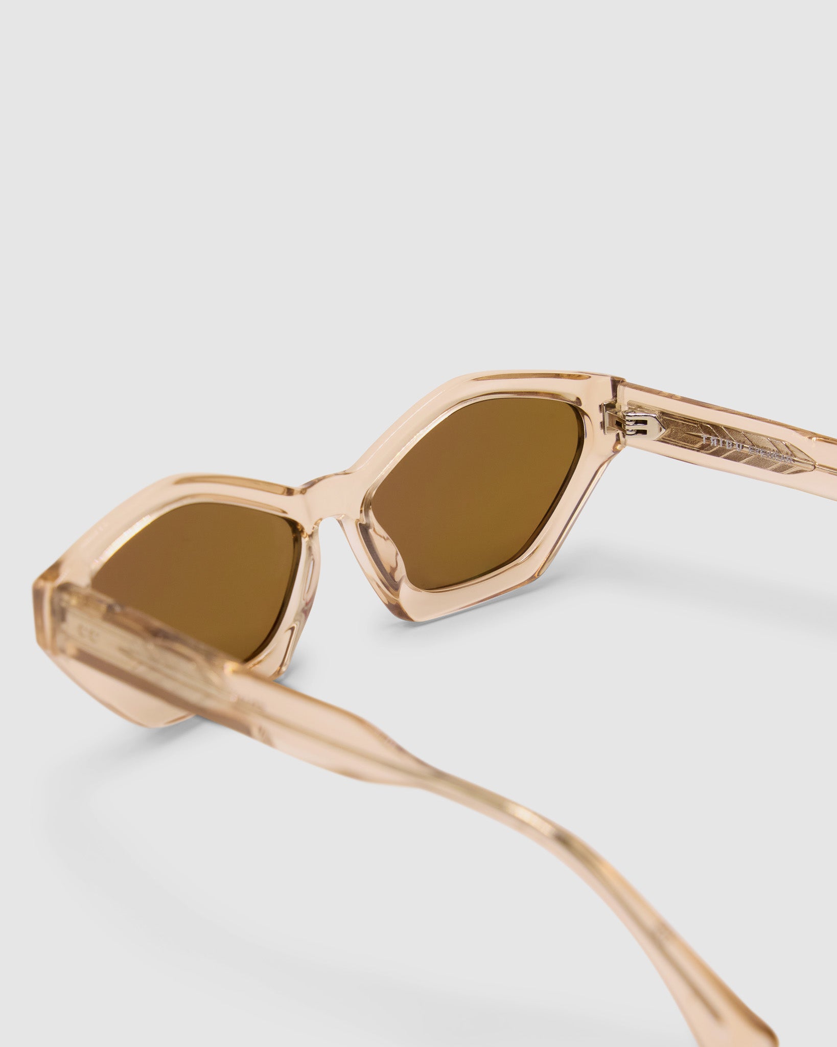 Franky Polarised Sunglasses by Tribu Eyewear — Champagne Crystal Cat-eye brown lens, detailed view, grey background.