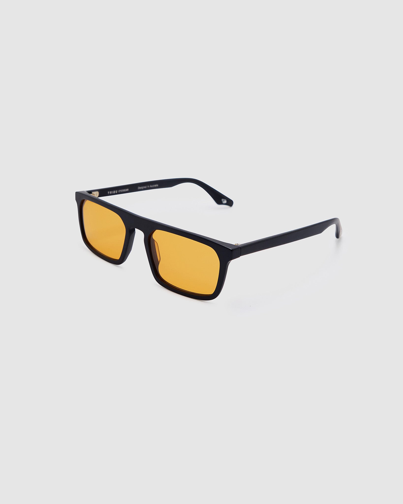 Gentleman Sunglasses by Tribu Eyewear — Matte balk acetate frame, desert orange lens side view on a grey background.