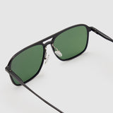 Oscar Sunglasses  by Tribu Eyewear — Metallic black aluminium aviator, green polarised lens, detailed view on light grey background. 
