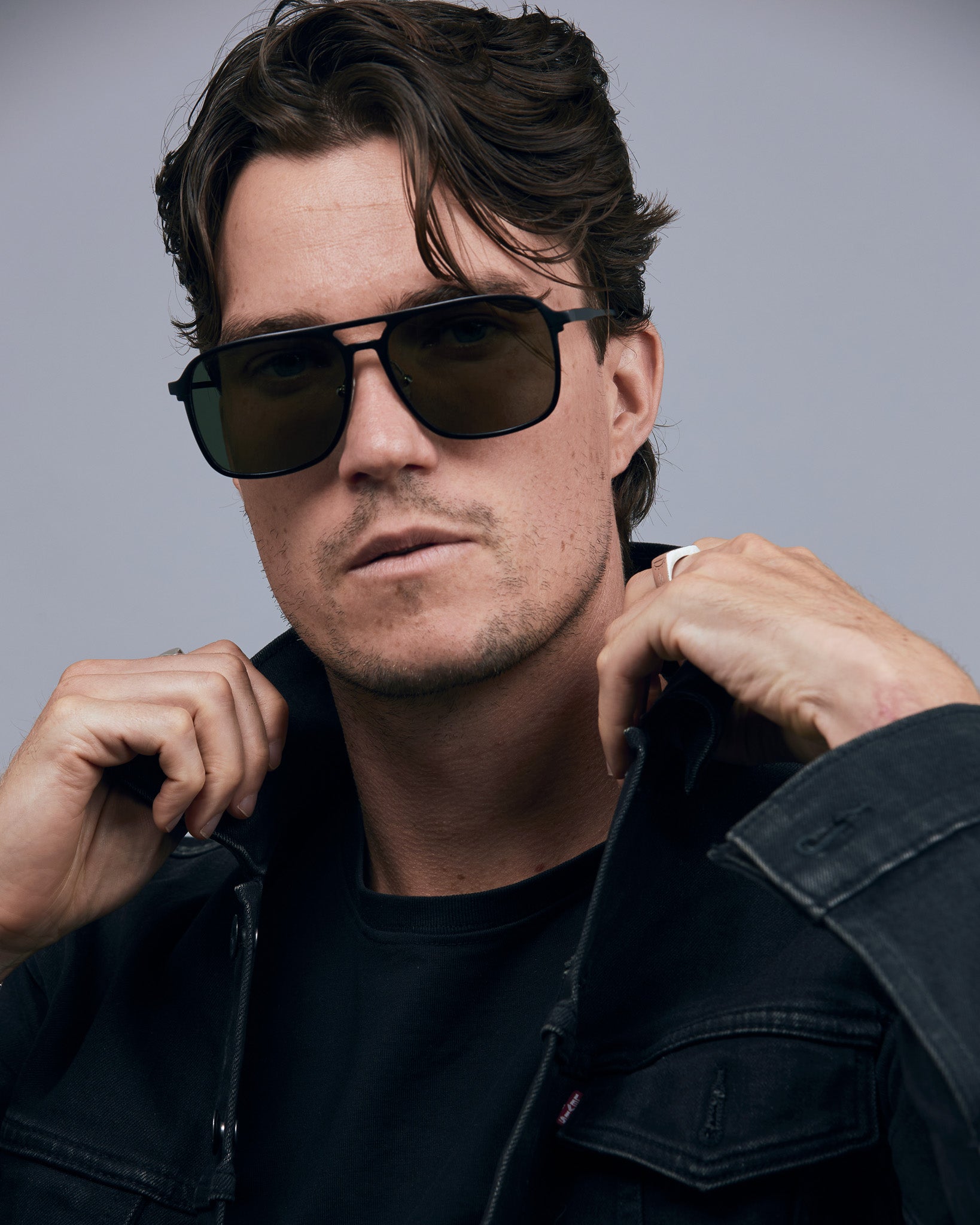 Oscar Sunglasses  by Tribu Eyewear — Metallic black aluminium aviator, green polarised lens on male model. 