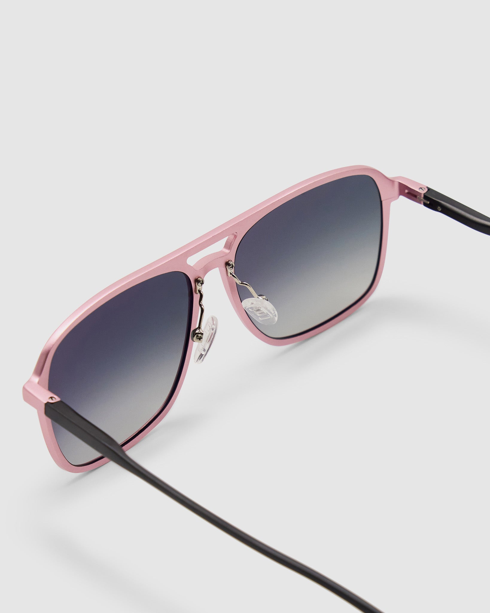 Oscar Sunglasses  by Tribu Eyewear — Metallic pink aluminium aviator, grey grad polarised lens, detailed view on grey background.