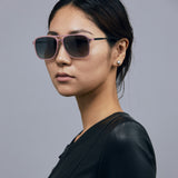 Oscar Sunglasses  by Tribu Eyewear — Metallic pink aluminium aviator, grey grad polarised lens, female model in studio. 