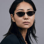 Model wearing TRIBU Nardi black and gold cat-eye sunglasses.
