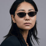 Model wearing TRIBU Nardi black and gold cat-eye sunglasses.