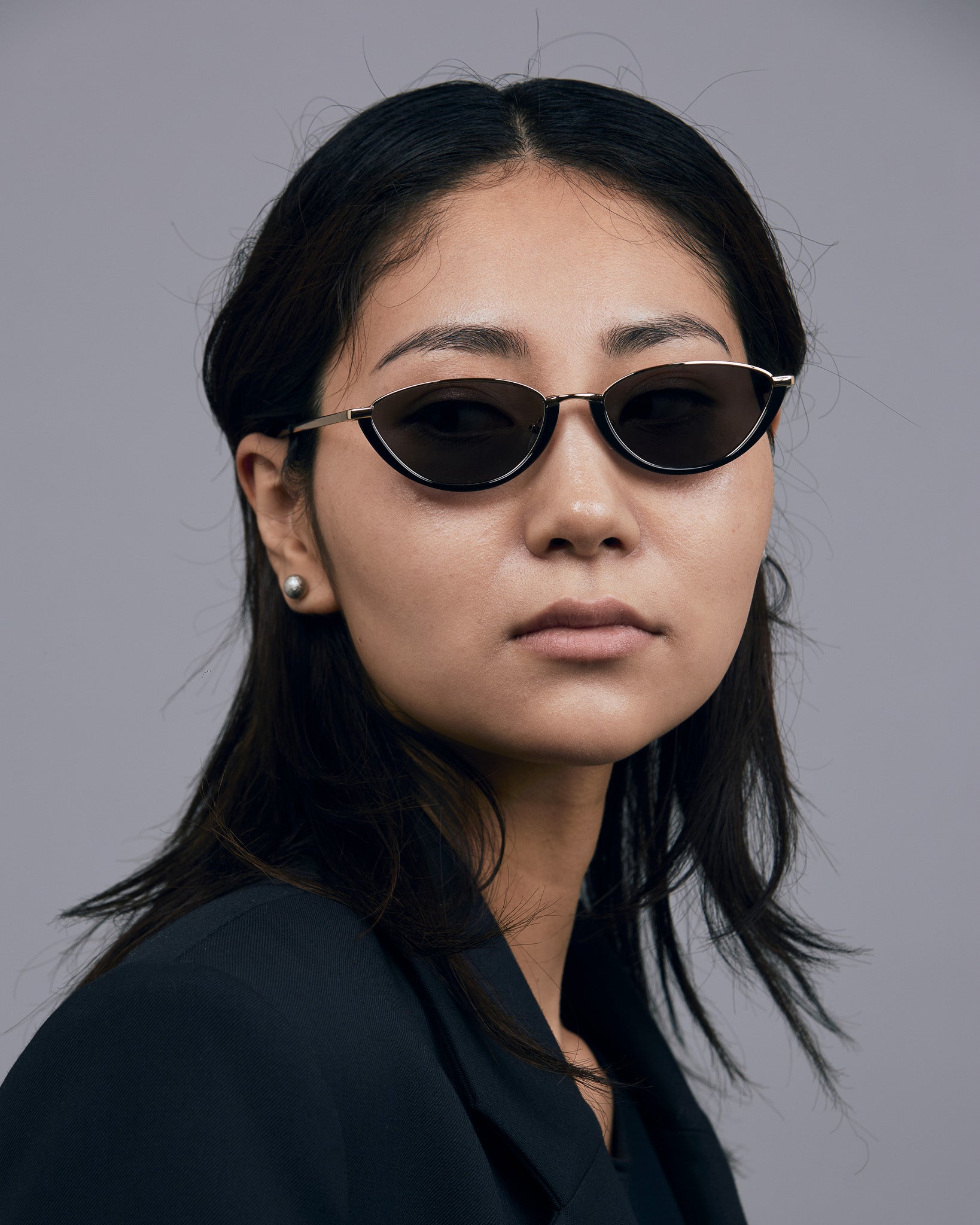 Model wearing TRIBU Nardi black and gold cat-eye sunglasses.