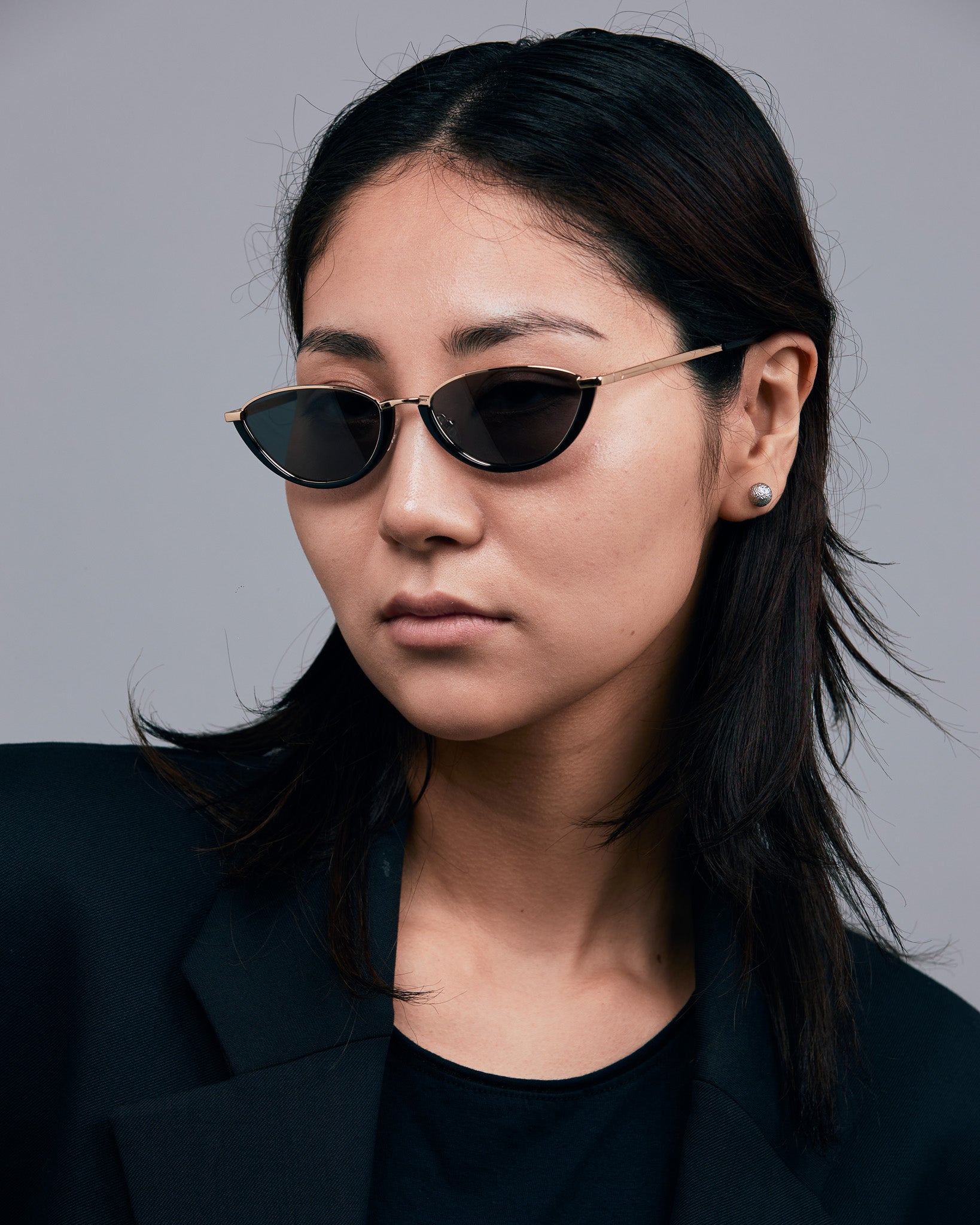 Model wearing TRIBU Nardi black and gold cat-eye sunglasses.